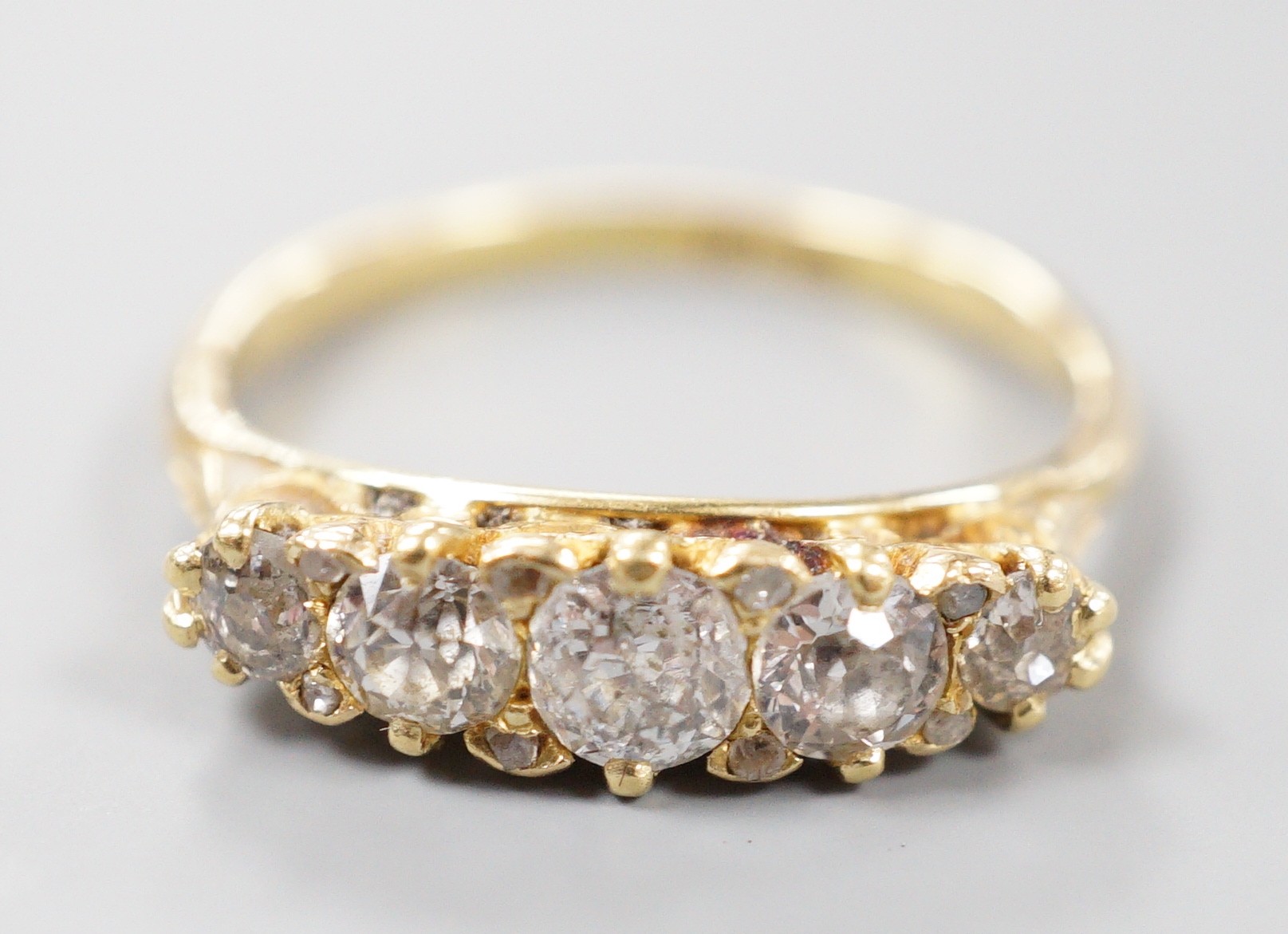 An early 20th century 18ct and graduated five stone diamond set half hoop ring, size P/Q, gross weight 3.2 grams.